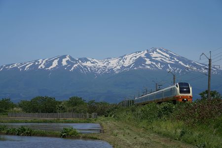 残雪の鳥海山と特急列車「いなほ」