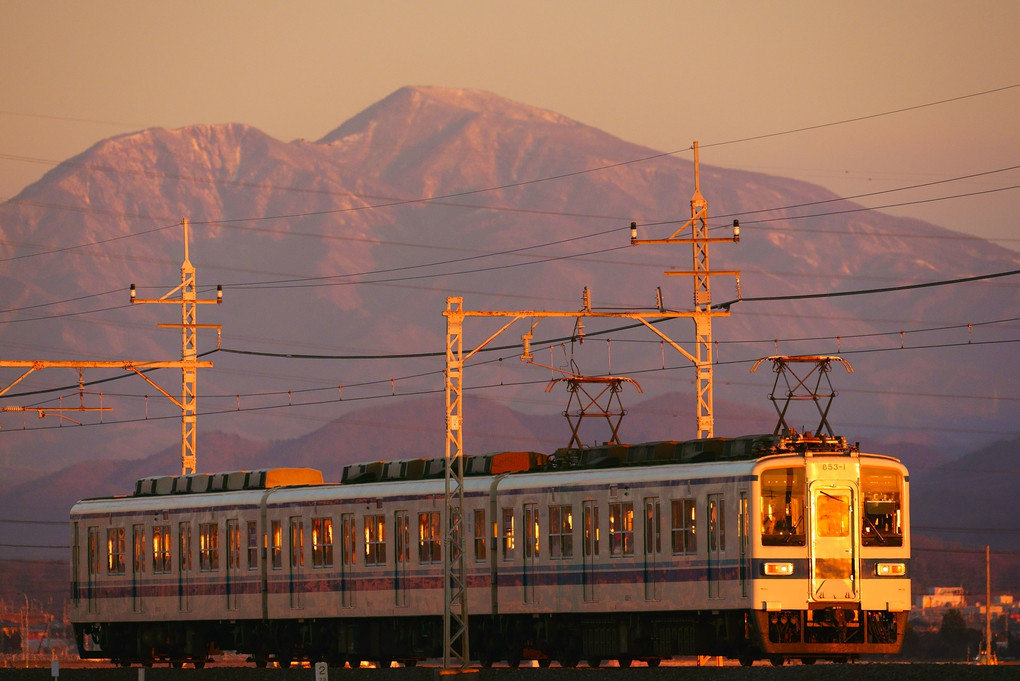 朝陽を浴びる赤城山と東武電車