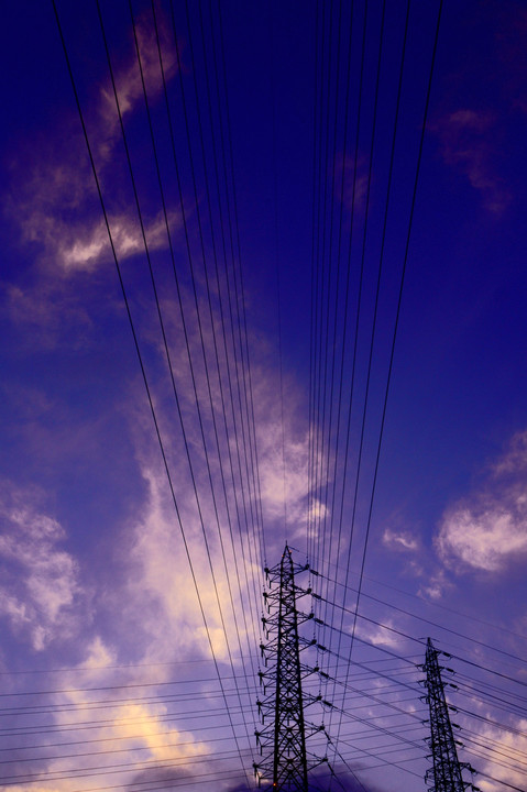 梅雨の合間の夕焼けに照らされる送電線と大橋