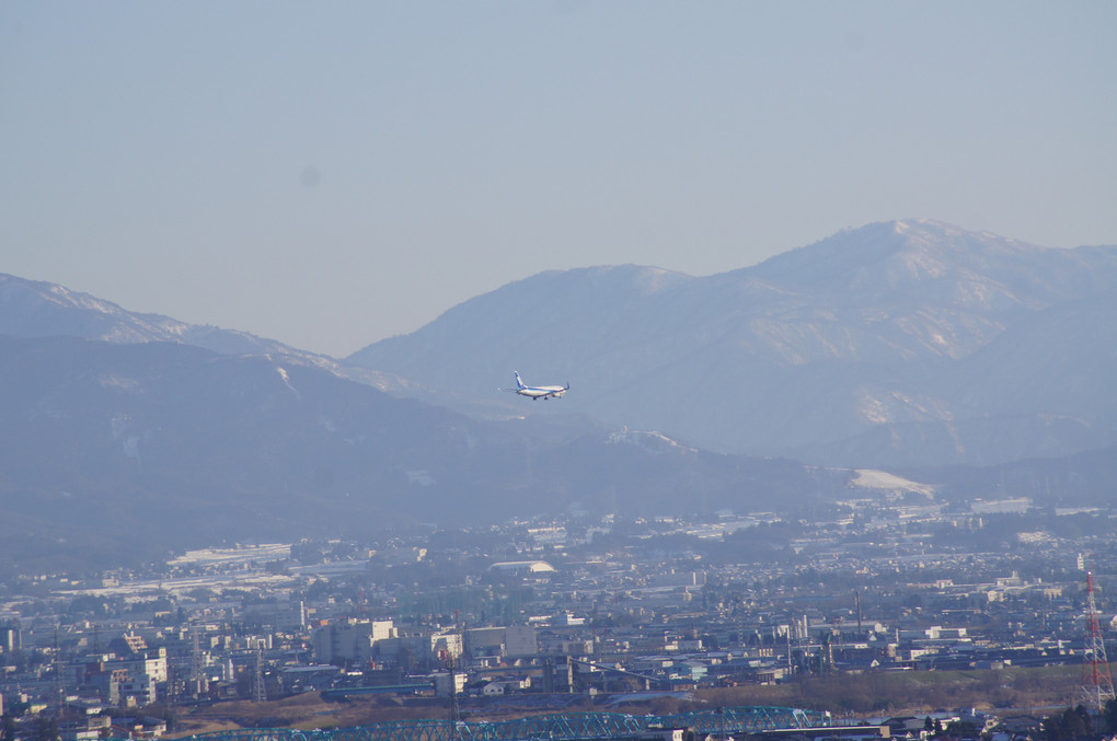 立山連峰と着陸する飛行機