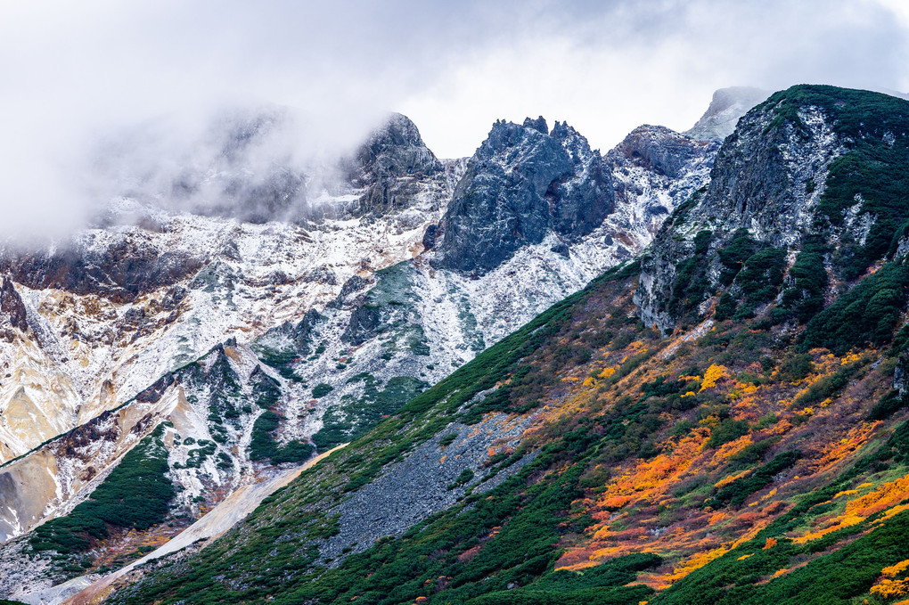 雪の積もった十勝岳連峰の山々と紅葉