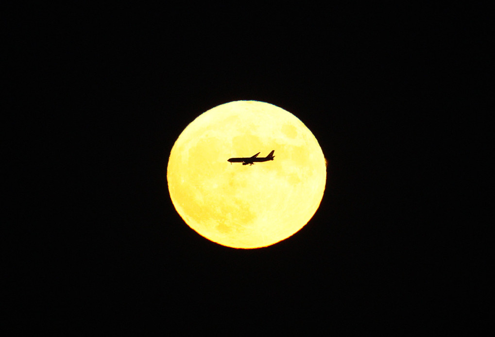 中秋の名月と横切る旅客機