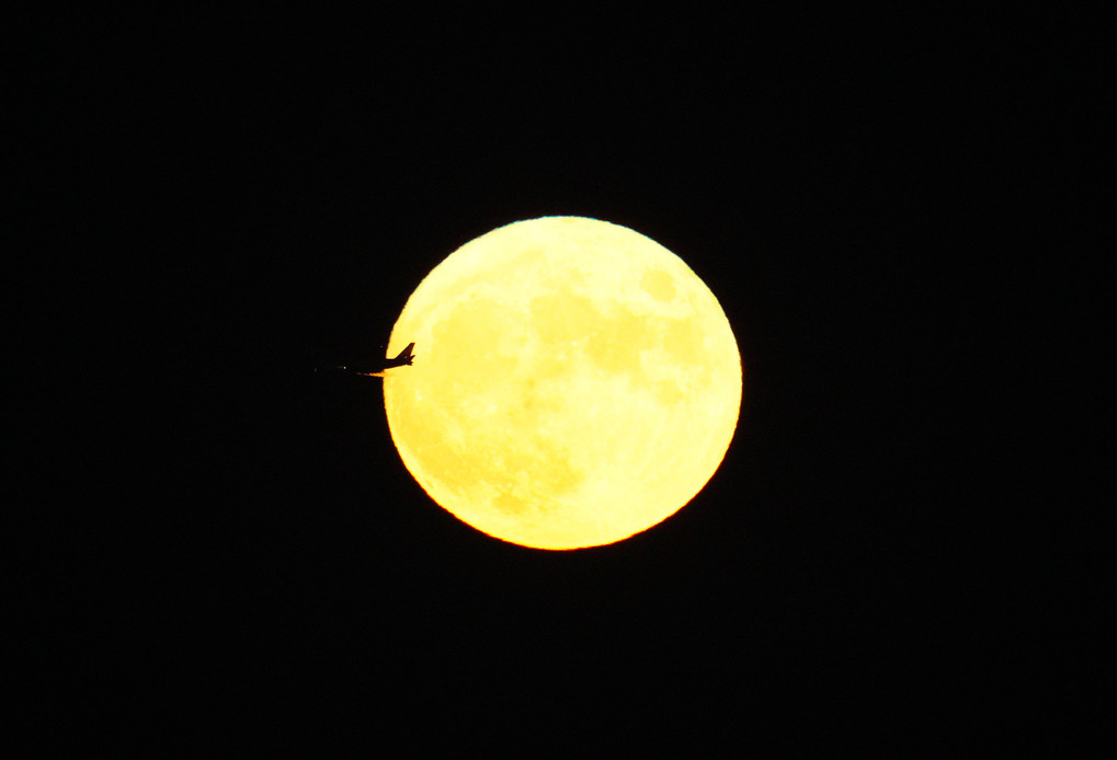 中秋の名月と横切る旅客機
