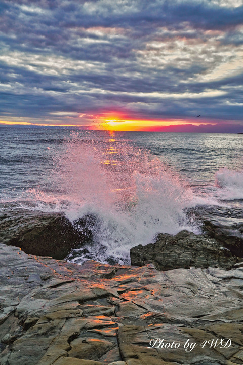 夕陽で染まる波、空、岩礁　　　