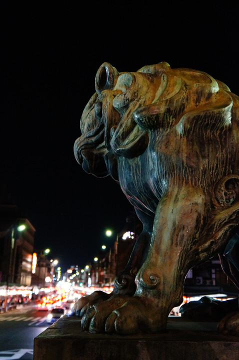 夜の四条通りを睨む八坂神社の狛犬