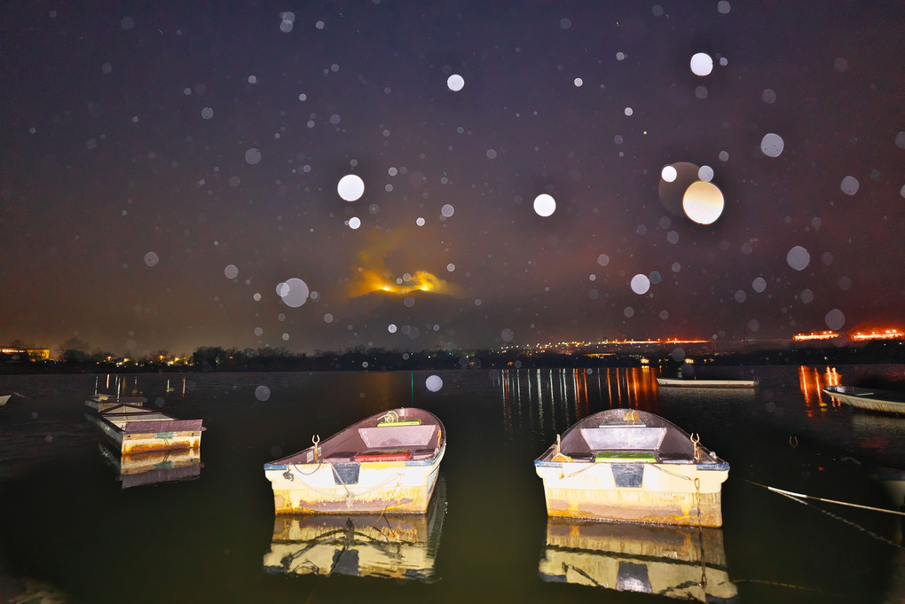 小雪降る湖に浮かぶ釣船