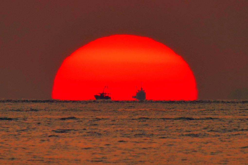 海に沈む夕日と船