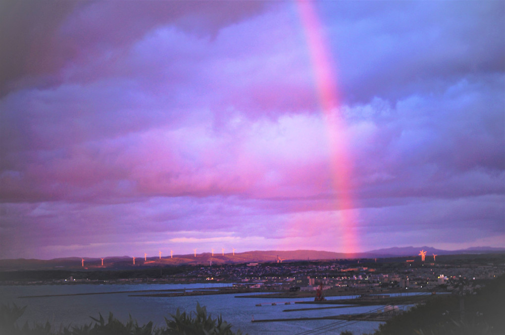 夕焼け染まる風力発電と虹（右側）