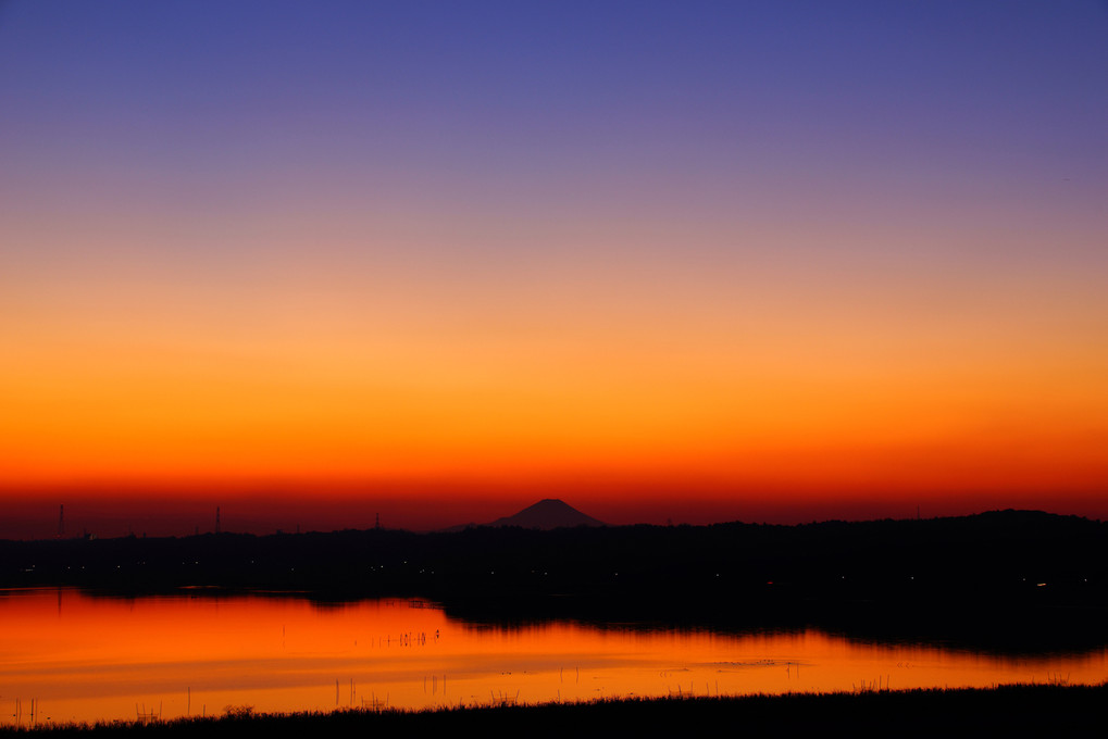グラデーションの空と夕焼けで照らされた湖面と富士山