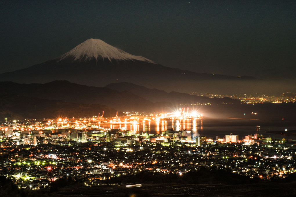 満月に照らされた新雪の富士山と港夜景