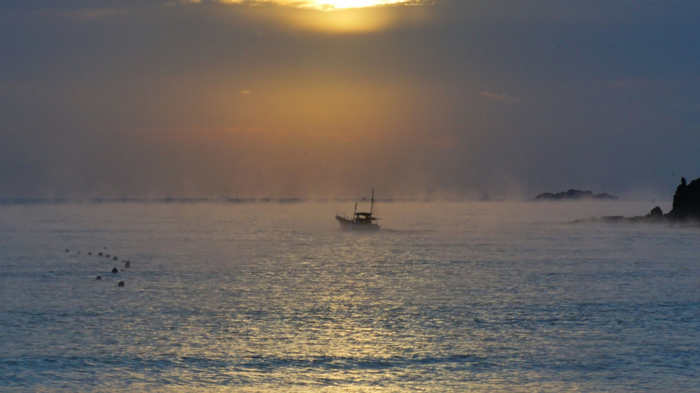 海霧の中出漁する漁船