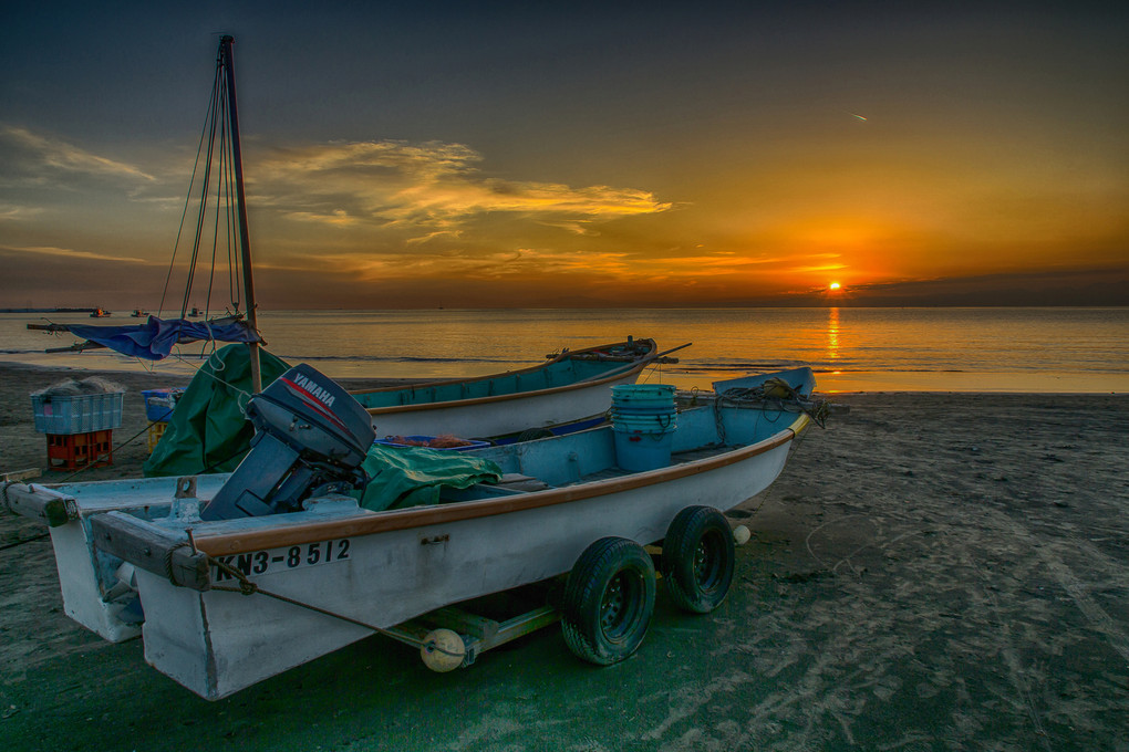 夕陽を眺める漁船の夫婦