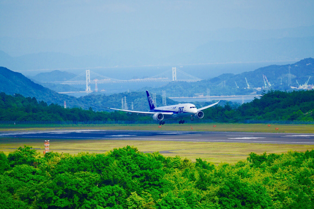 因島大橋を背景に広島空港へ着陸するB787