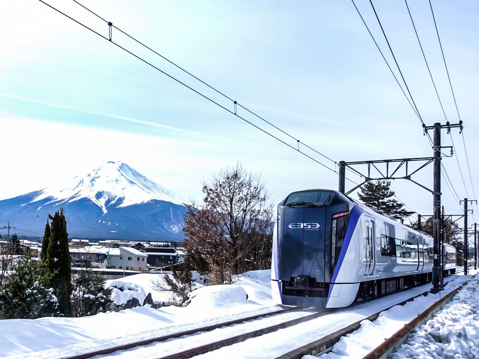 雪景色を走行する特急「富士回遊」号と富士山