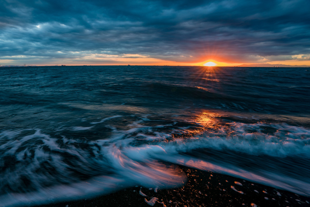 波の中へ沈む夕日。