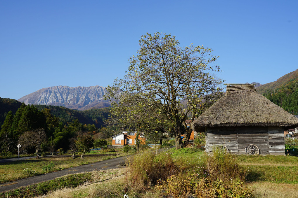 大山と茅葺き小屋