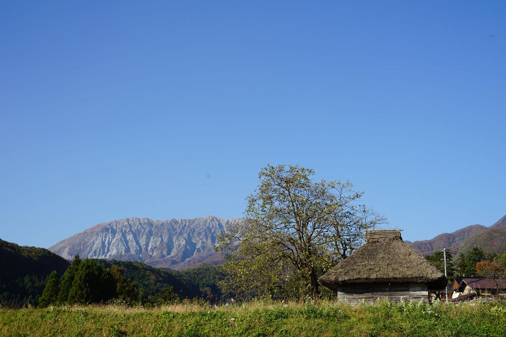 大山と茅葺き小屋