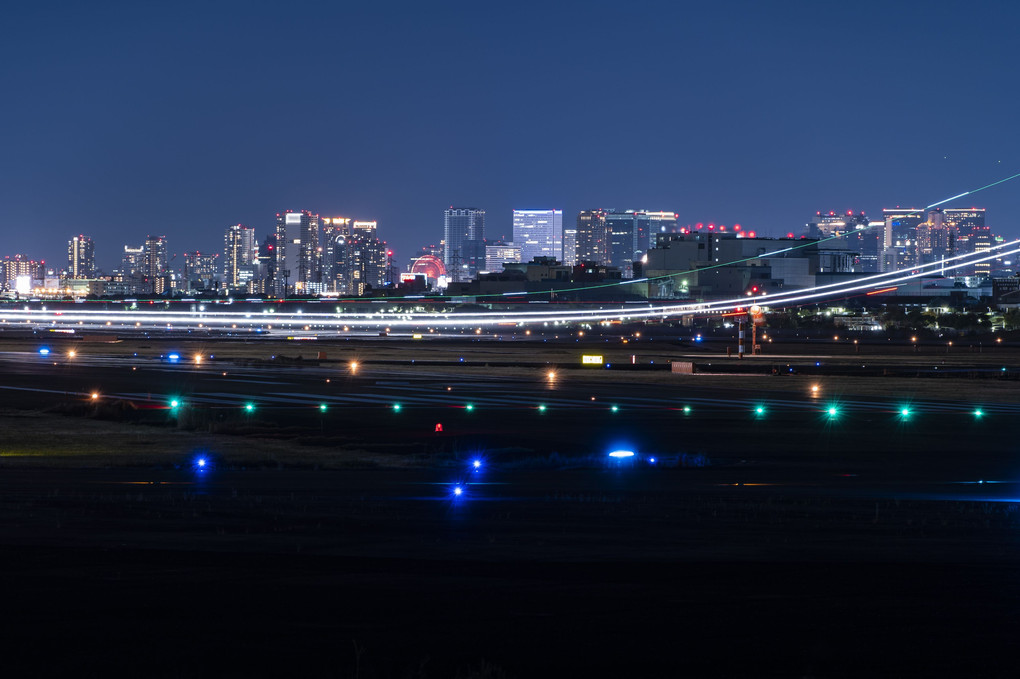 飛行機の光跡と大阪夜景