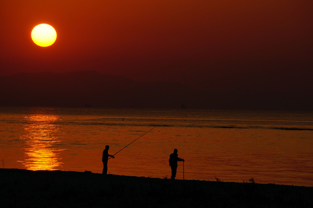 夕日と釣り人と老人