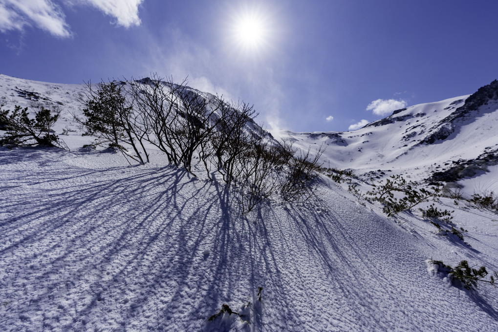 雪煙と伸びる影