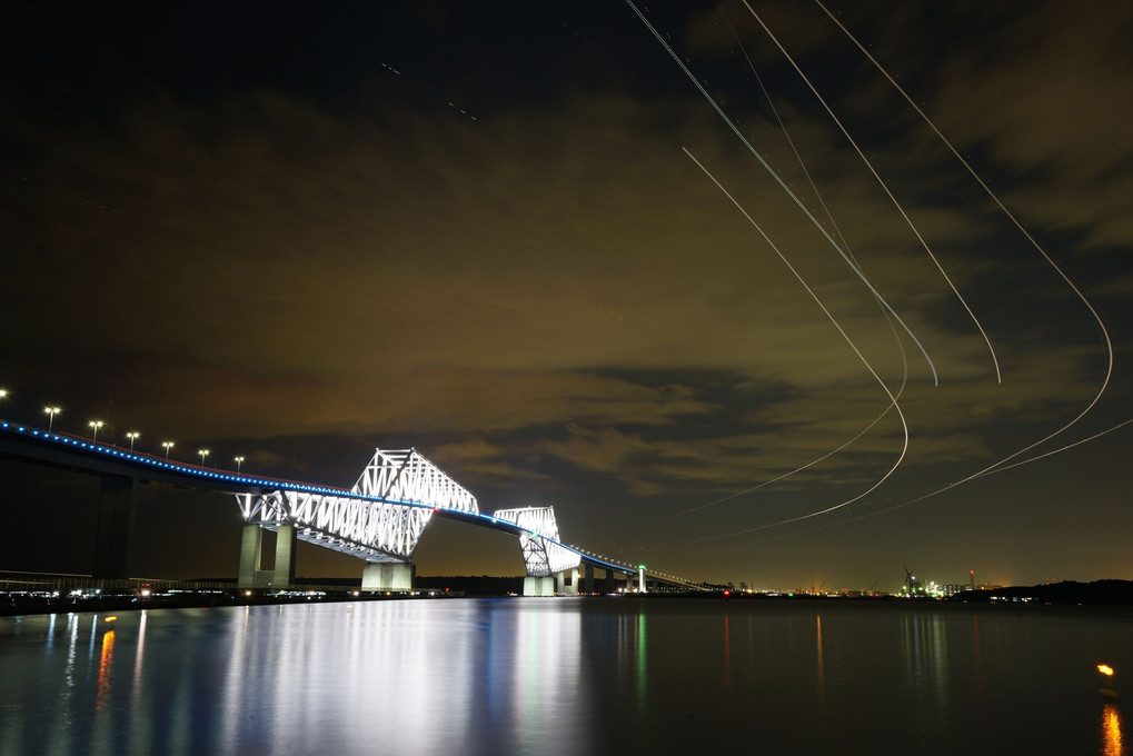 東京ゲートブリッジと羽田を飛び立つ飛行機の光跡