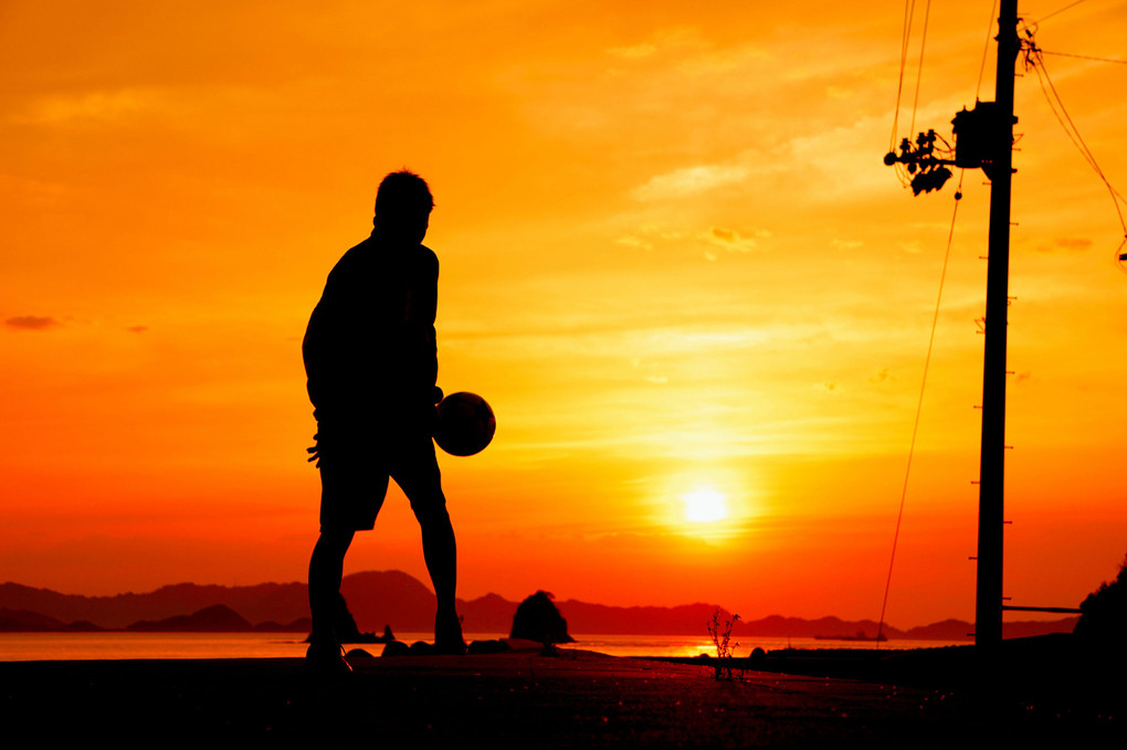 夕陽とサッカー少年