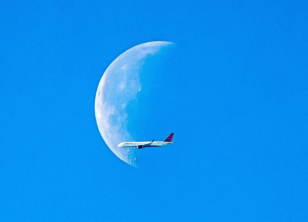 早朝の月と旅客機