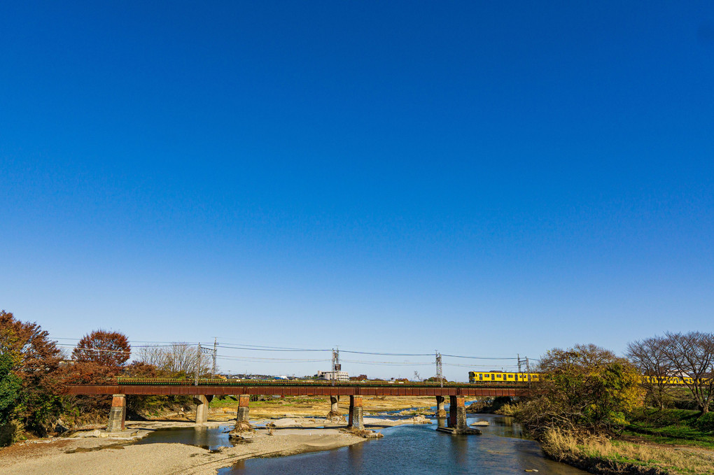 晩秋の入間川と青空と黄色い電車