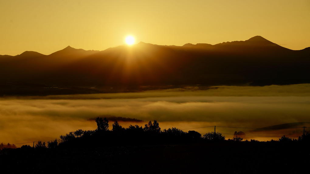 十勝岳連峰からの日の出と街を覆う雲海