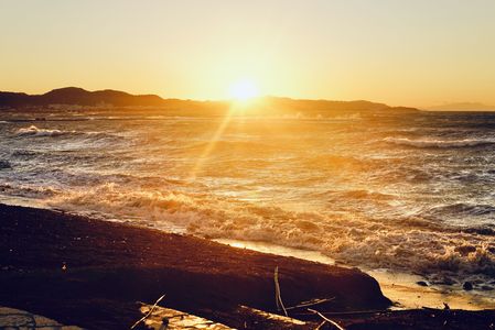 風の波が寄せる海岸の日の入り