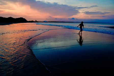 茜色の海辺を走る子ども