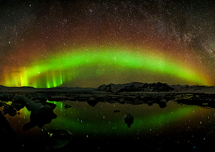アイスランドの氷河湖にかかるオーロラ